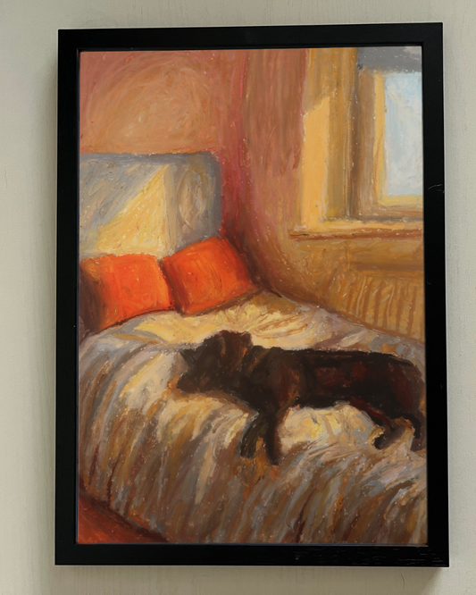 Framed painting of a dog on a bed with orange pillows in a warm-toned room.